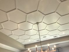 a chandelier hanging from the ceiling in a room with hexagonal tiles