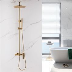 a bathtub and shower head in a white bathroom with marble walls, flooring and windows