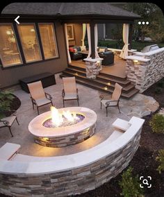 an outdoor fire pit with chairs around it