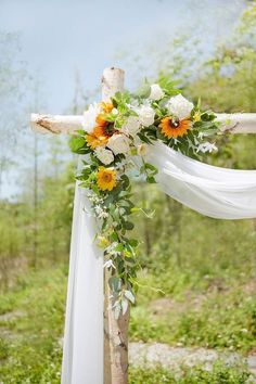 a cross decorated with sunflowers and greenery