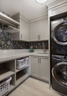 a washer and dryer sitting in a kitchen next to each other on top of cabinets