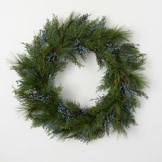 a green wreath with blue berries and pine needles