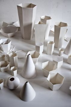 many white vases and cups are scattered on the floor