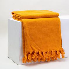 an orange towel is sitting on top of a white box and it's folded up