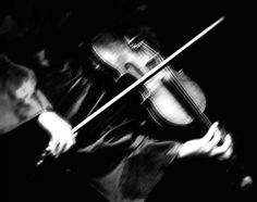 a woman is playing the violin in black and white