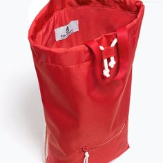 a red tote bag sitting on top of a white table