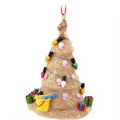 a christmas tree ornament hanging from a string with lights and presents on it