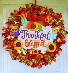 a wreath that says, happy thanksgiving and is decorated with sunflowers and leaves