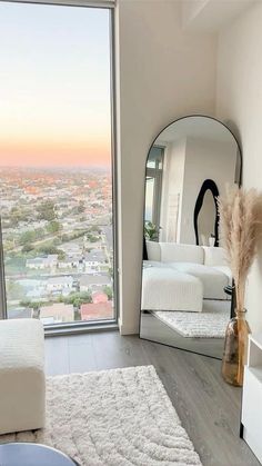 a living room filled with furniture and a large mirror on the wall next to a window