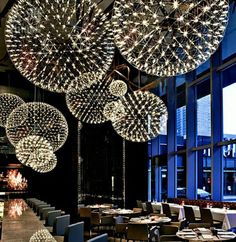 a restaurant with large chandeliers hanging from the ceiling and tables set for dinner