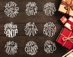 six christmas gift tags on a wooden surface with presents around them and the words merry santa written in white ink