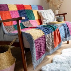 a multicolored crocheted blanket sitting on top of a couch in a living room