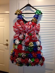 a red, white and blue christmas tree hanging on a door hanger with bows