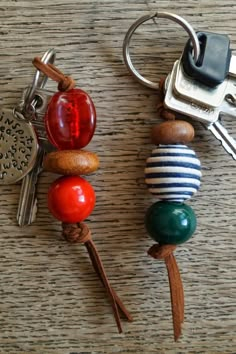 two keys are attached to each other on a table with key chains and charms hanging from them