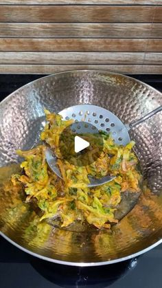 a metal bowl filled with food on top of a stove