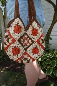 a woman is holding a crocheted bag in her hands