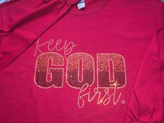 Keep God First Rhinestone Shirt is available in unisex sizes small to 5X. Long sleeves. Brand: Gildan Ultra Cotton.  Color:  Cardinal Red Fabric: 100% cotton - preshrunk Due to the nature of custom garments no returns or exchanges accepted unless the garment is defective. Rhinestone Cotton Crew Neck T-shirt, Graphic Tee With Rhinestones And Crew Neck, Keep God First, Rhinestone Shirt, Rhinestone Shirts, God First, Faith Based, Red Fabric, Long Sleeve T Shirt