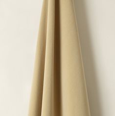 a beige curtain hanging on a white wall