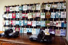 a wooden table topped with lots of cards on clothes pins attached to a pegboard