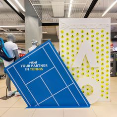 there are two tennis rackets on display in the store, one is blue and the other is white