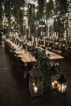 a long table with candles and greenery is set up for an outdoor dinner party