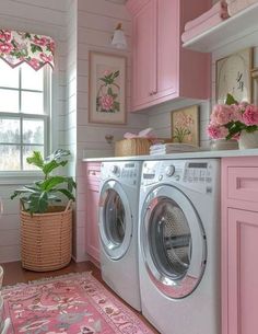 a washer and dryer in a small room with pink decor on the walls