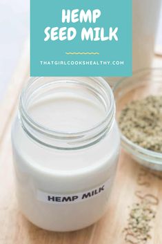 a jar of hemp seed milk sitting on top of a wooden cutting board next to a