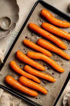 carrots are lined up on a baking sheet and ready to be cooked in the oven