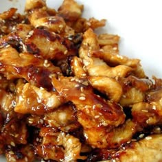 chicken with sesame seeds and sauce on a white plate