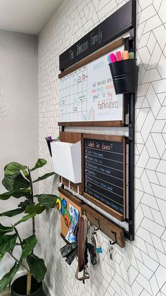 a bulletin board mounted to the side of a wall next to a potted plant