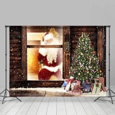 a christmas tree and presents in front of a window with santa's face on it