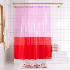 a pink and red shower curtain in a bathroom with white tiles on the floor,