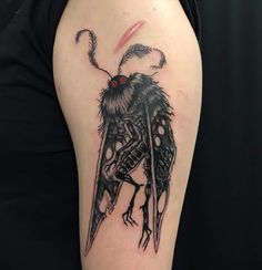 a black and white photo of a tattoo with a bug on it's arm