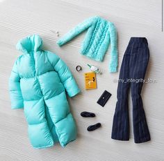 an assortment of clothing and accessories laid out on the floor, including a sleeping bag