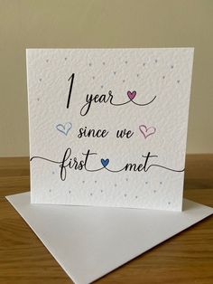 a card with the words 1 year since we first met on it, and hearts