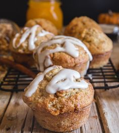 muffins with white icing sitting on a cooling rack