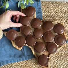 a wooden tray topped with chocolate cupcakes on top of a table