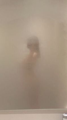 a blurry image of a person standing in front of a mirror