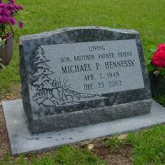 the headstone of michael p henessy is surrounded by flowers