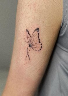 a small butterfly tattoo on the arm