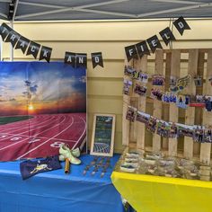 a table topped with pictures and other items next to a blue table cloth covered wall