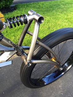 a close up of a bike parked on the side of a road with grass in the background