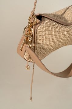 a beige purse with gold chains hanging from it