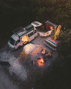 an aerial view of a camper van and rv parked next to each other in the woods