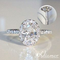 a diamond ring is shown with an oval shaped center surrounded by smaller round brilliant cut diamonds