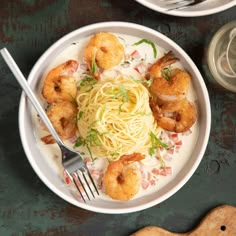 a white plate topped with pasta and shrimp