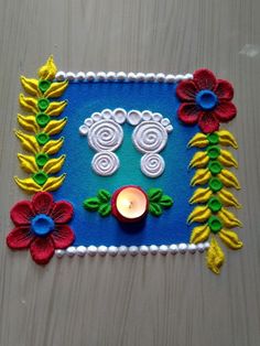 this is an image of a colorful decoration with flowers and candles on the table next to it