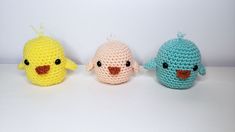 three small crocheted birds sitting next to each other on a white counter top