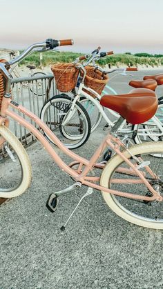 two bicycles parked next to each other in front of a parking lot with baskets on the back