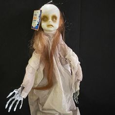 a creepy doll with long red hair and white makeup